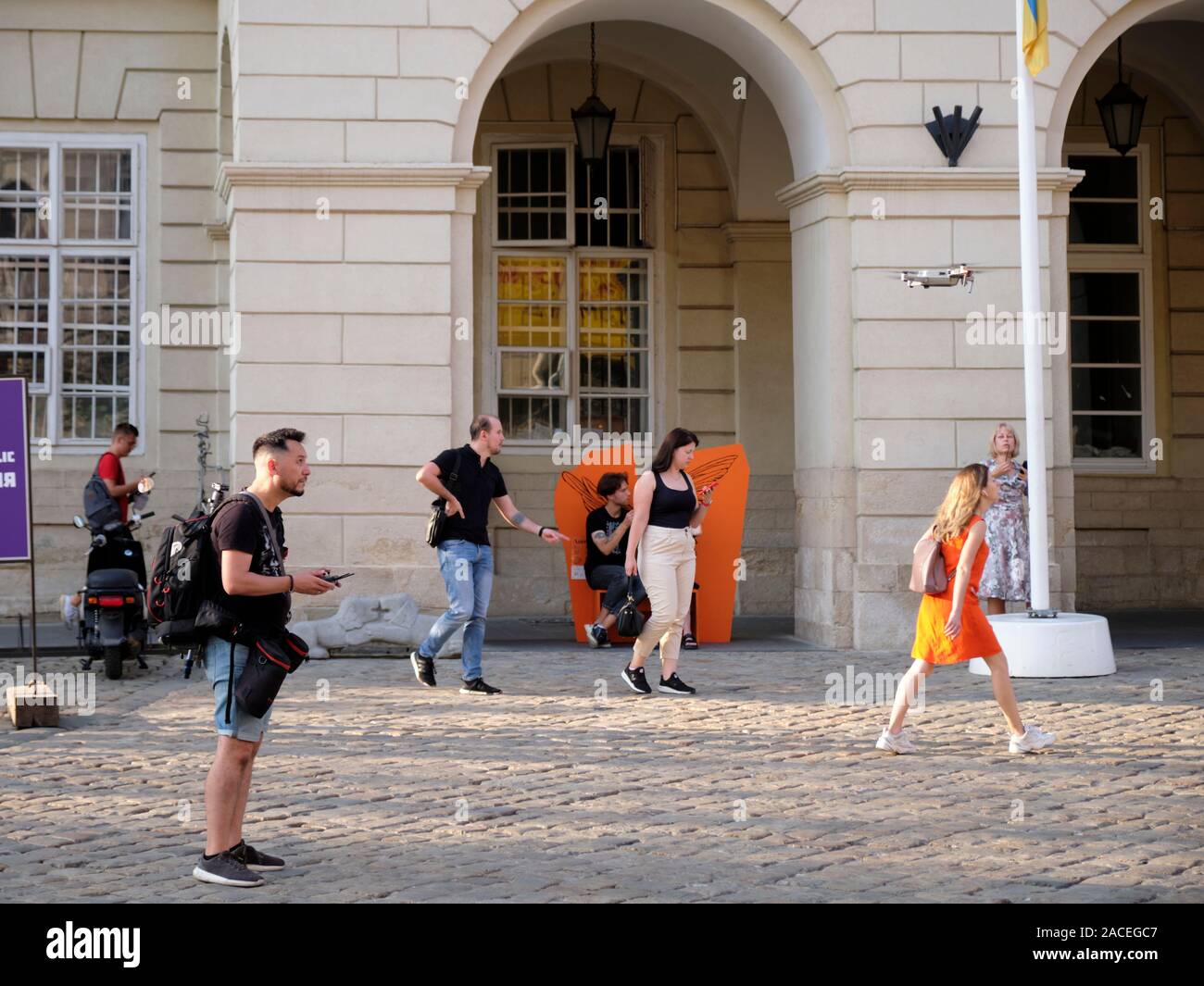 Photographer flying a hand manned drone in Rynok Square, the centre of Lviv, Ukraine Stock Photo