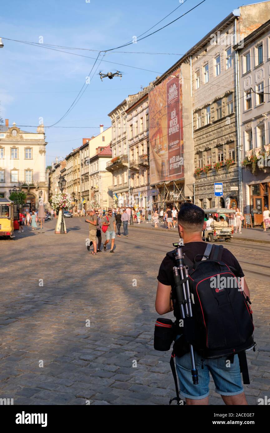 Photographer flying a hand manned drone in Rynok Square, the centre of Lviv, Ukraine Stock Photo