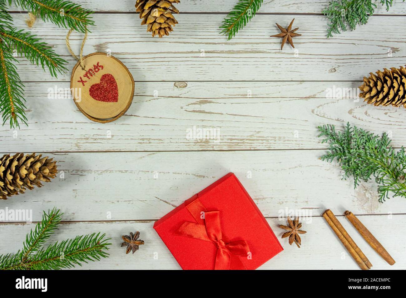 Christmas frame background flat lay on white wood with other natural decoration and red gift box . Stock Photo