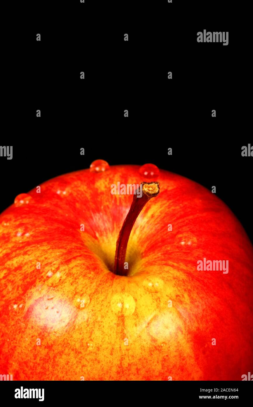 Red eating apple isolated on a black background with water drops Stock Photo