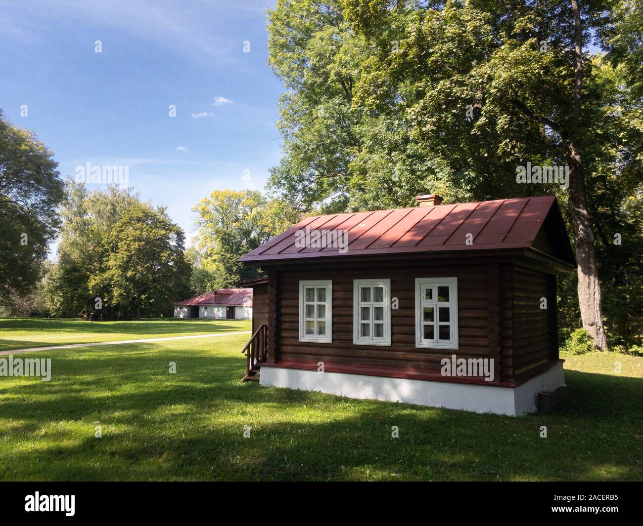 Tiny wooden house on green lawn in sunny day. Spasskoe-Lutovinovo, Turgenev's estate copy space Stock Photo