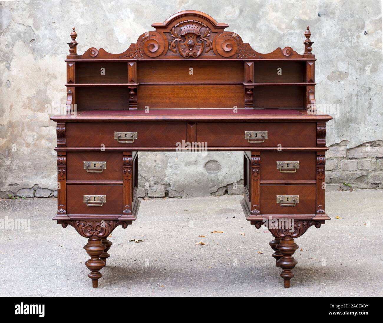 Antique wooden mahogany writing desk with wood carvings Stock Photo