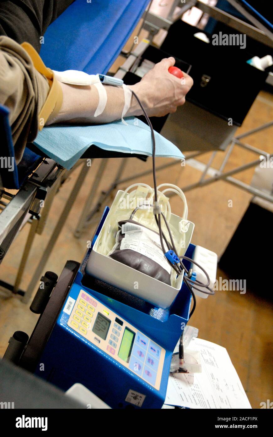 Donating blood. Donor squeezing a rubber ball to encourage good