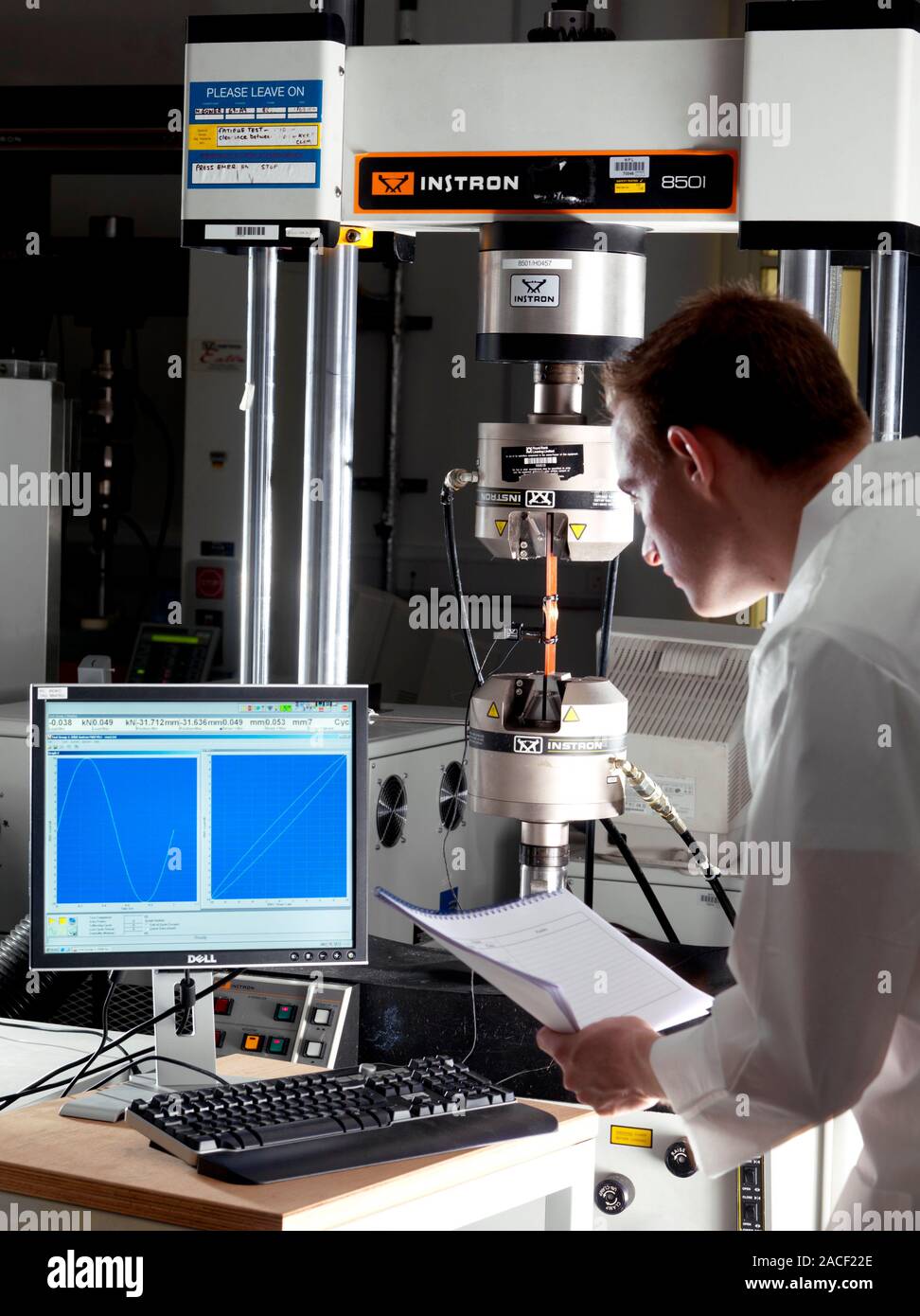 Materials testing. Technician testing an object in a typical mechanical ...