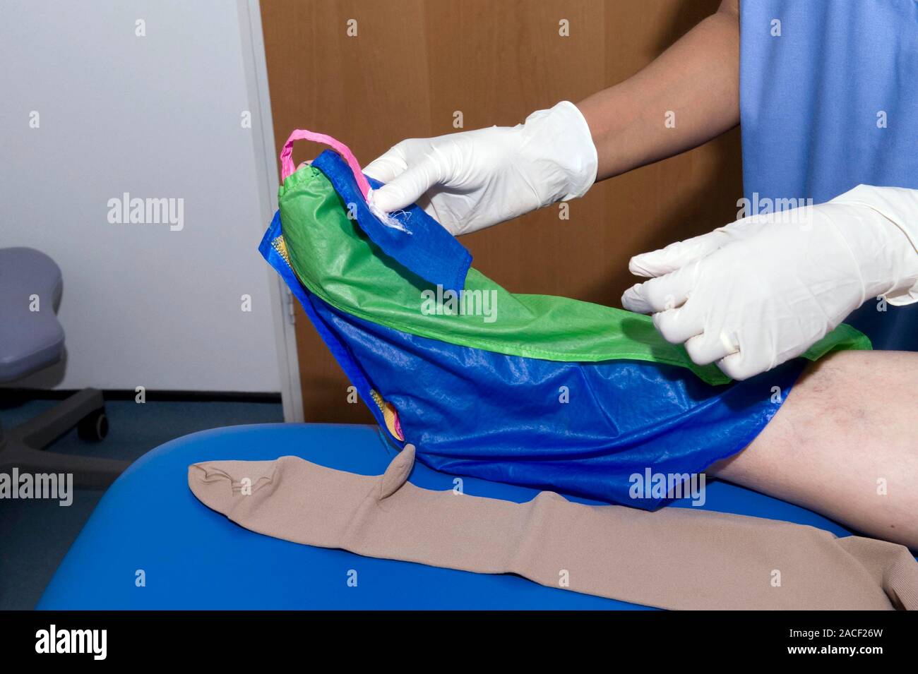 Fitting surgical stockings. Image 1 of 3. A patient being fitted with