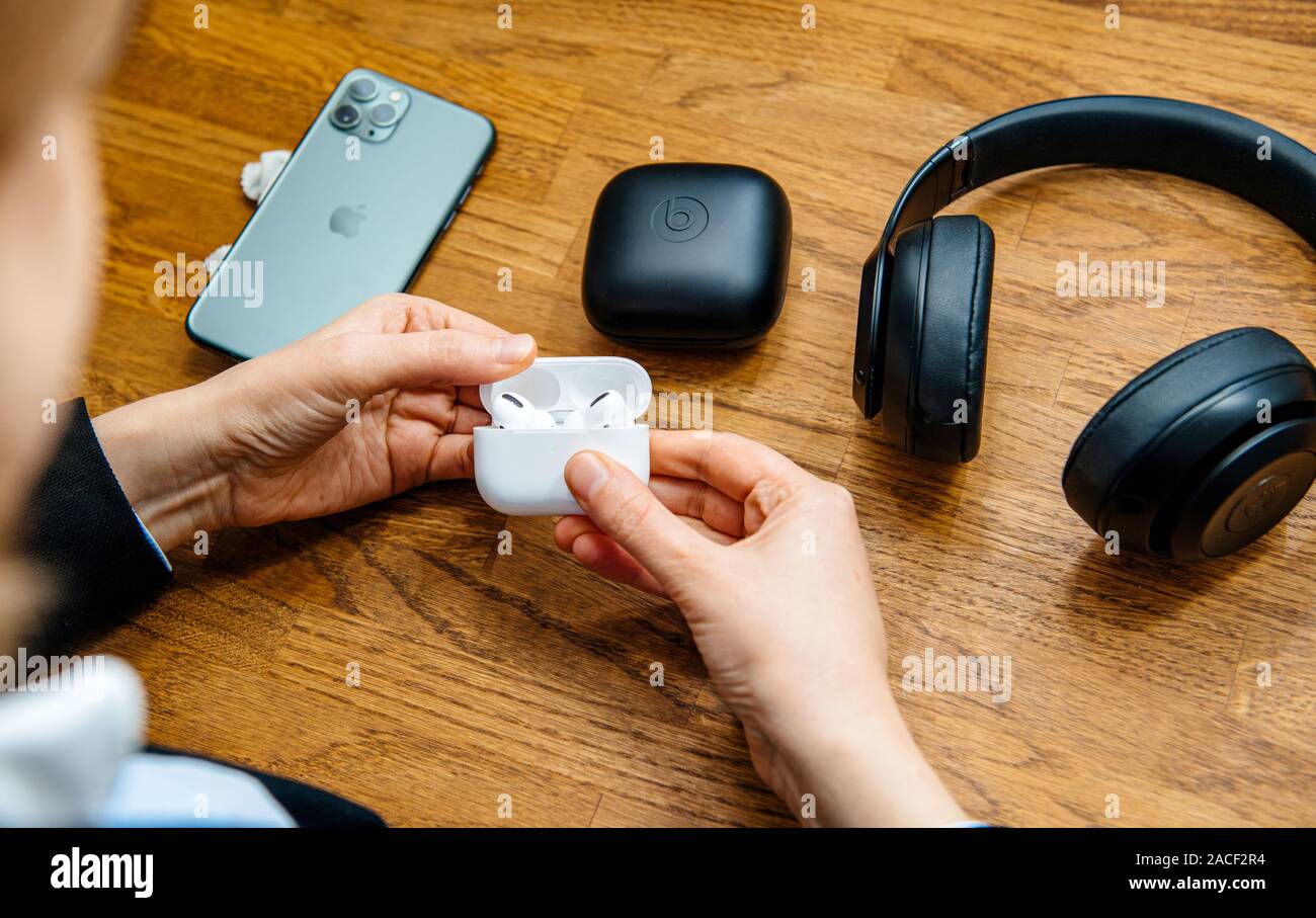 Paris, France - Oct 30, 2019: Overhead view of woman hands unboxing new Apple Computers AirPods Pro headphones with Active Noise Cancellation for immersive sound other Beats by Dr Dre headphones Stock Photo