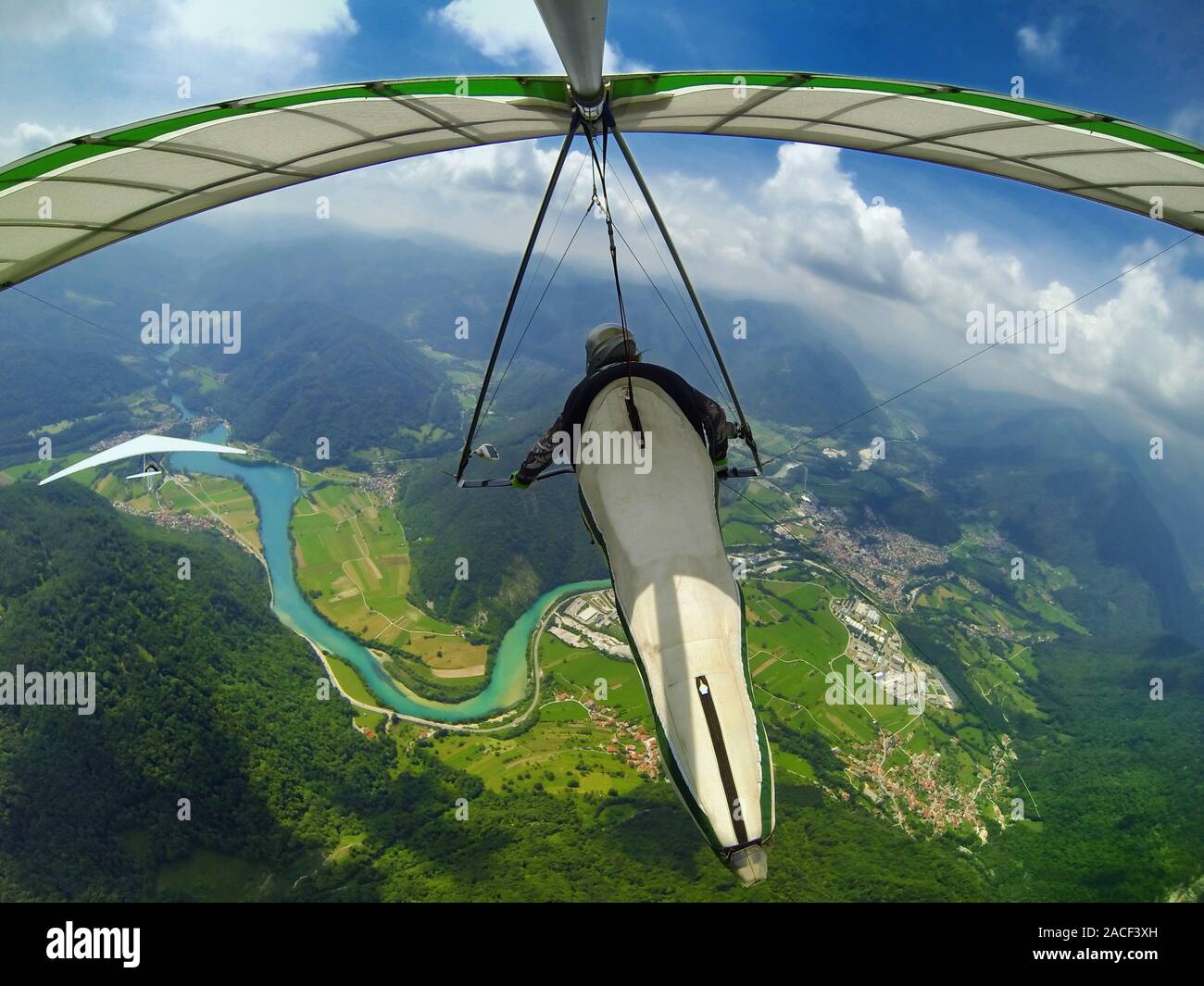 Two hang glider pilots fly above beautiful scenery of Soca valley in Slovenia Stock Photo