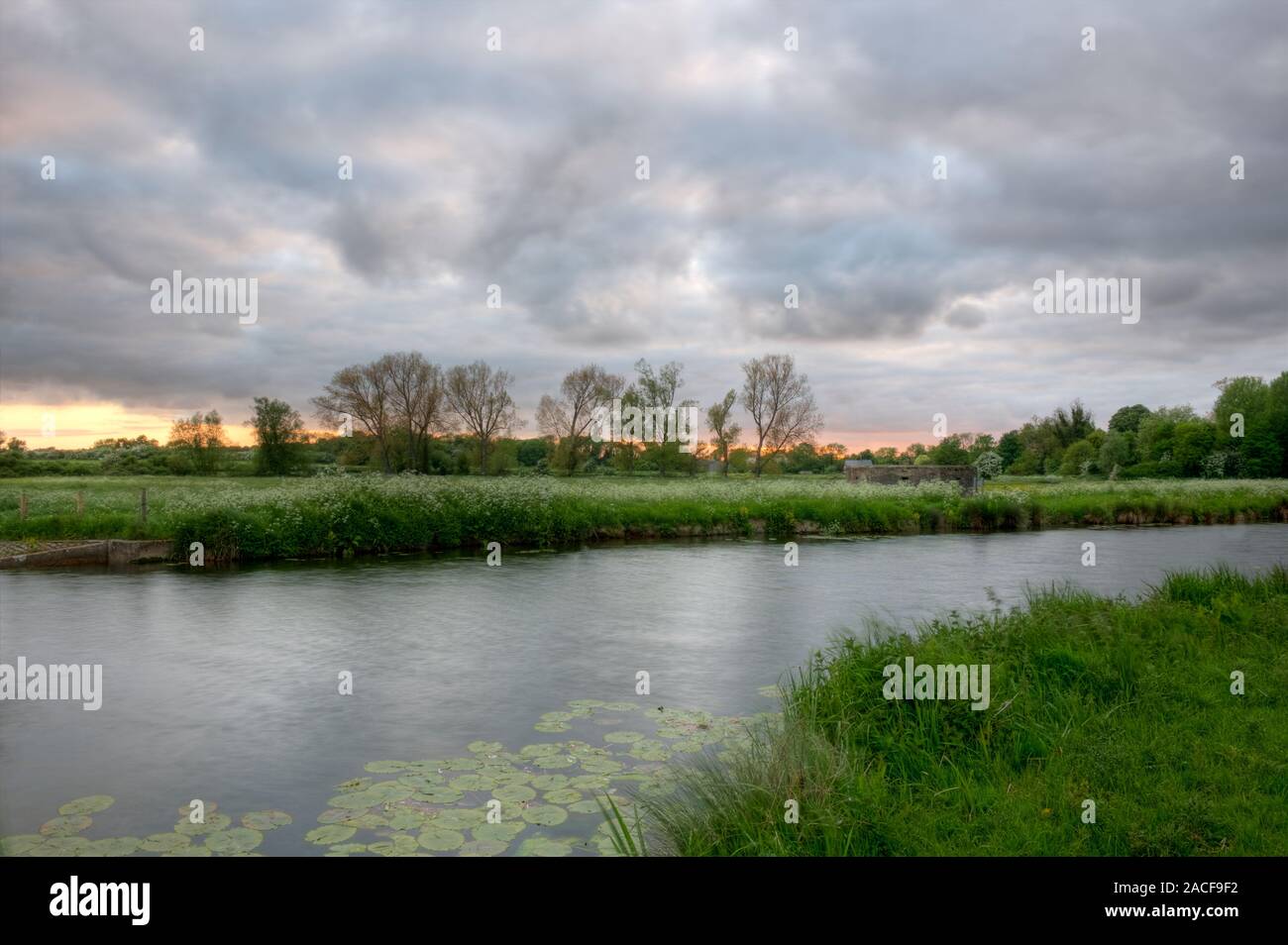 storm clouds gather across the River Stour looking towards the old WWII pillbox. Stock Photo
