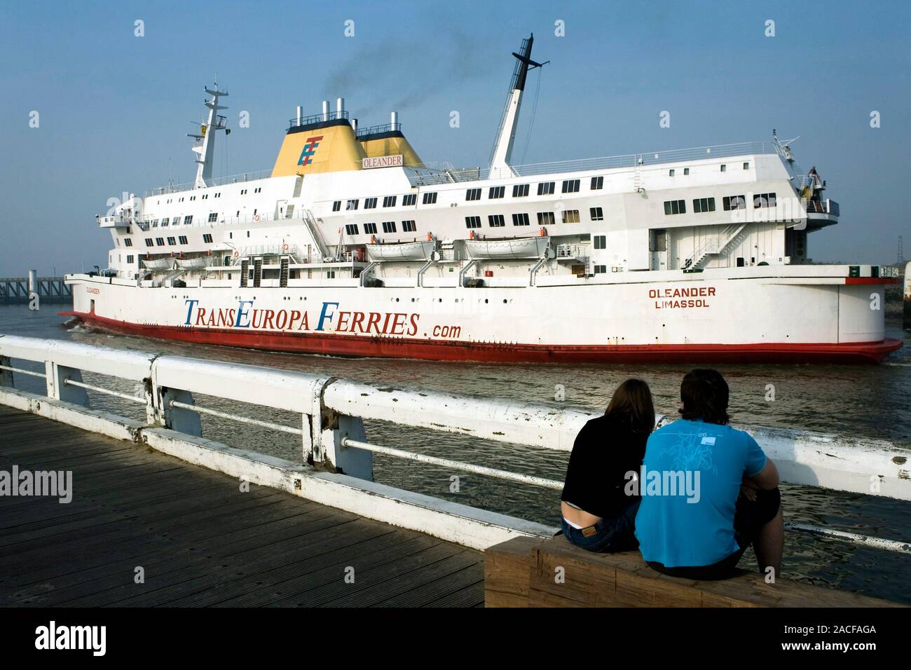 Passenger ferry. Couple watching a ferry in a port. Photographed at