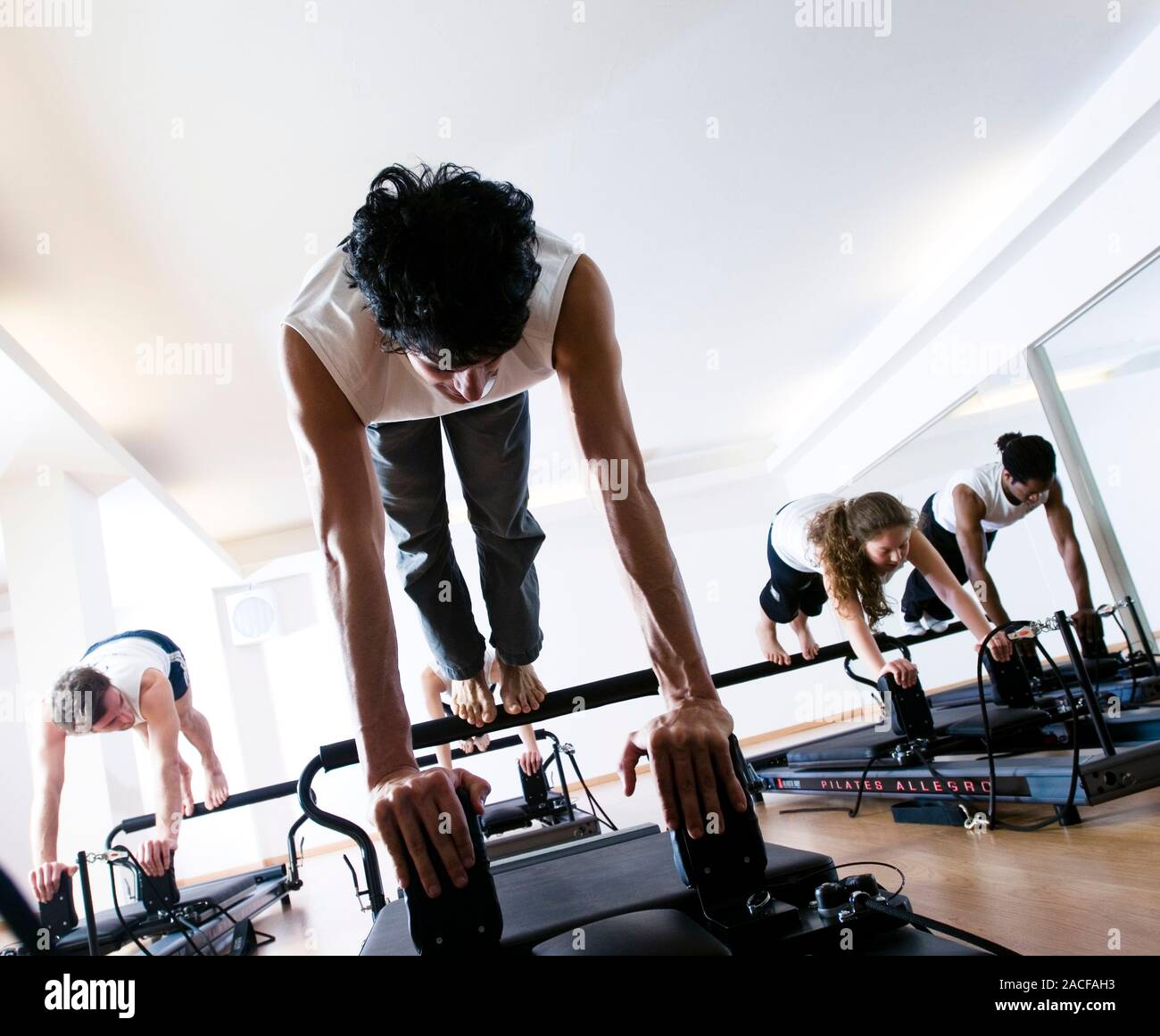 Pilates class. People using pilates exercise equipment during a class. Stock Photo