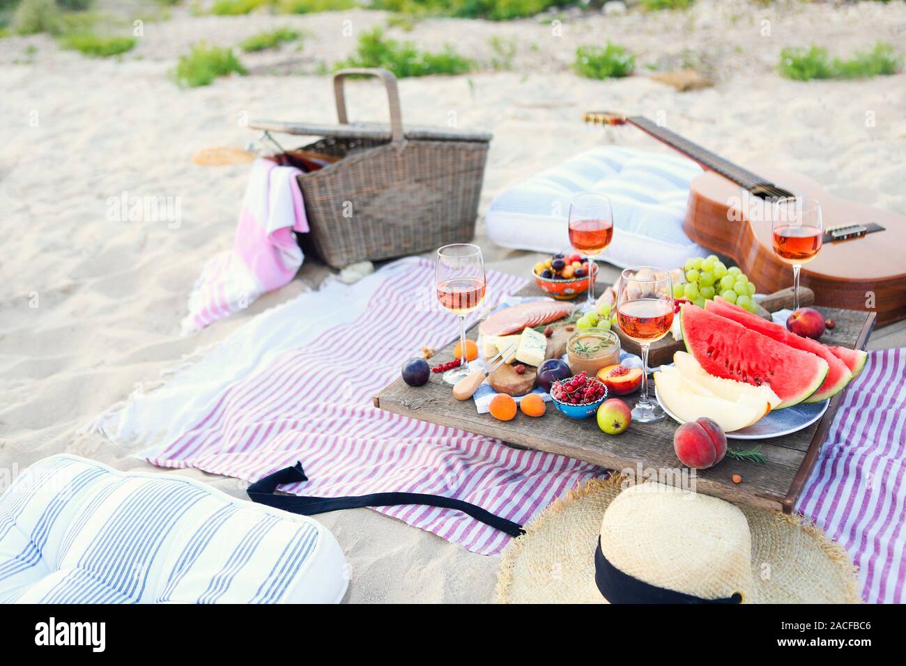 Picnic on the beach at sunset in the style of boho. Food and drink, relax, holiday concept Stock Photo