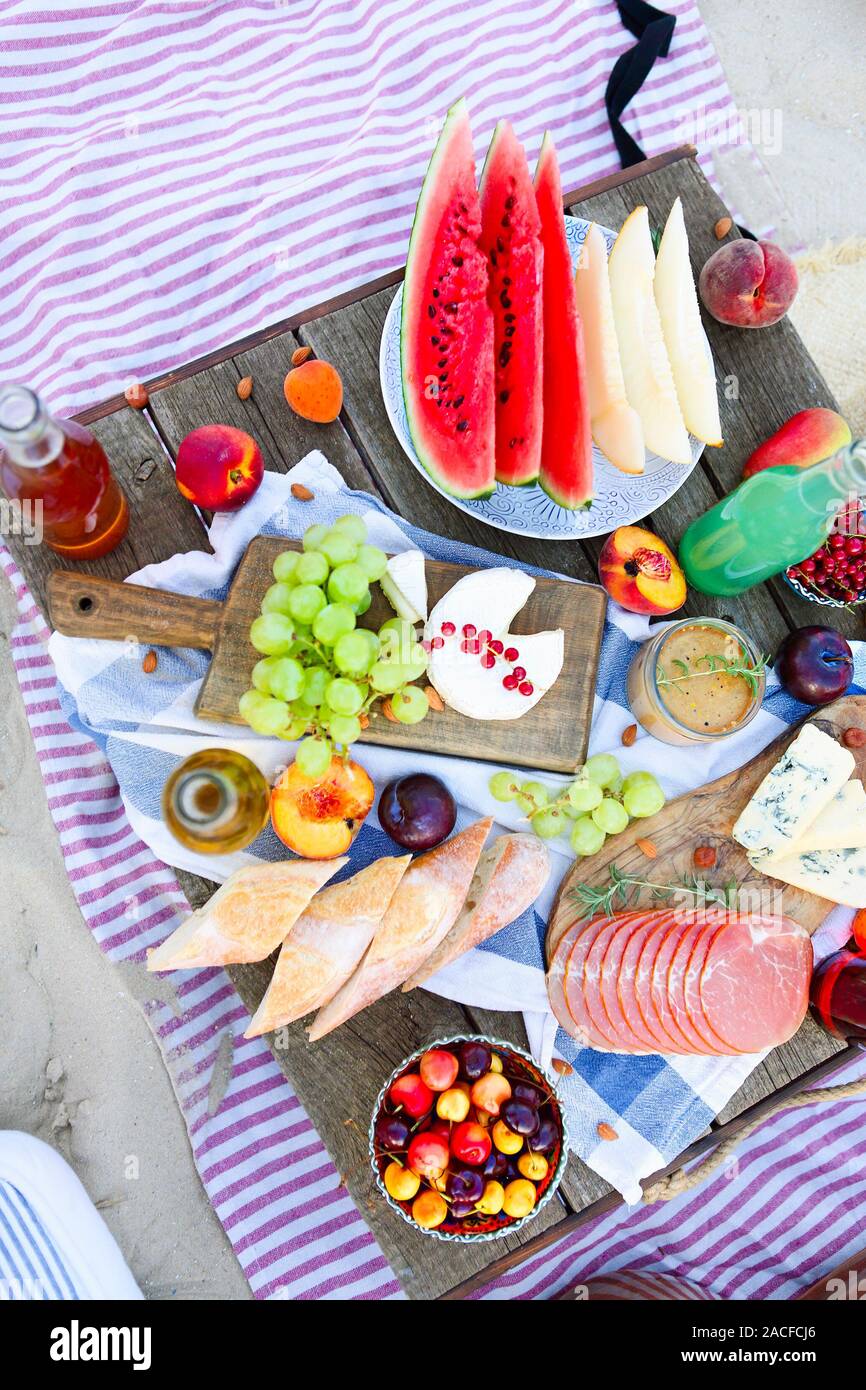 Picnic on the beach at sunset in the style of boho. Food and drink, relax,  holiday concept Stock Photo - Alamy