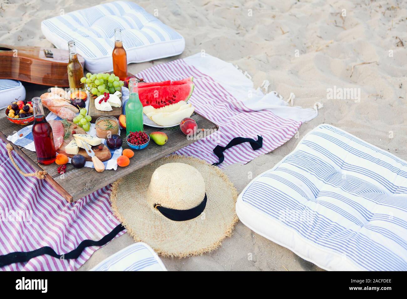 Picnic on the beach at sunset in the style of boho. Food and drink, relax, holiday concept Stock Photo