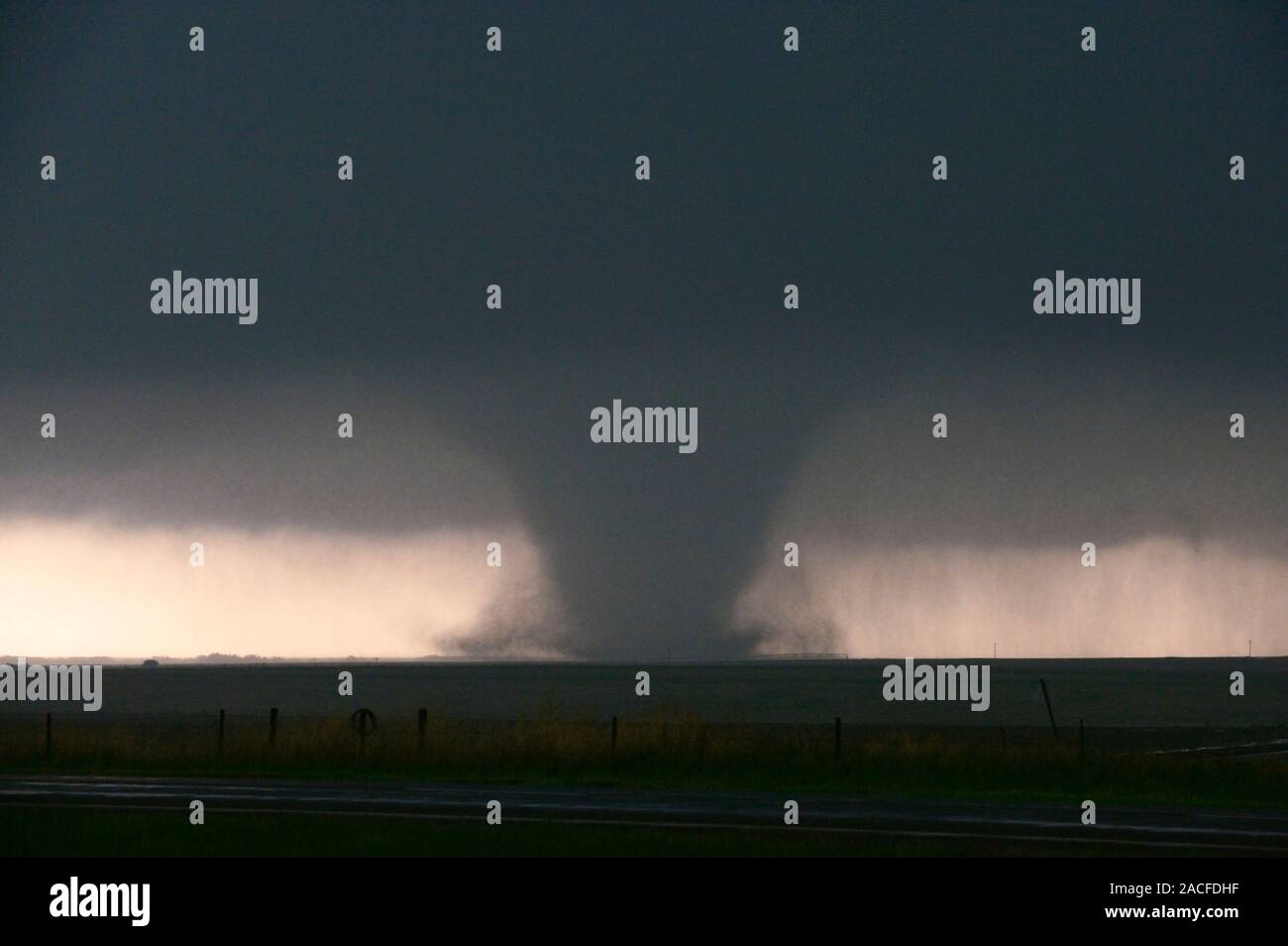 Large tornado darkening the sky. A tornado is a violent rotating column