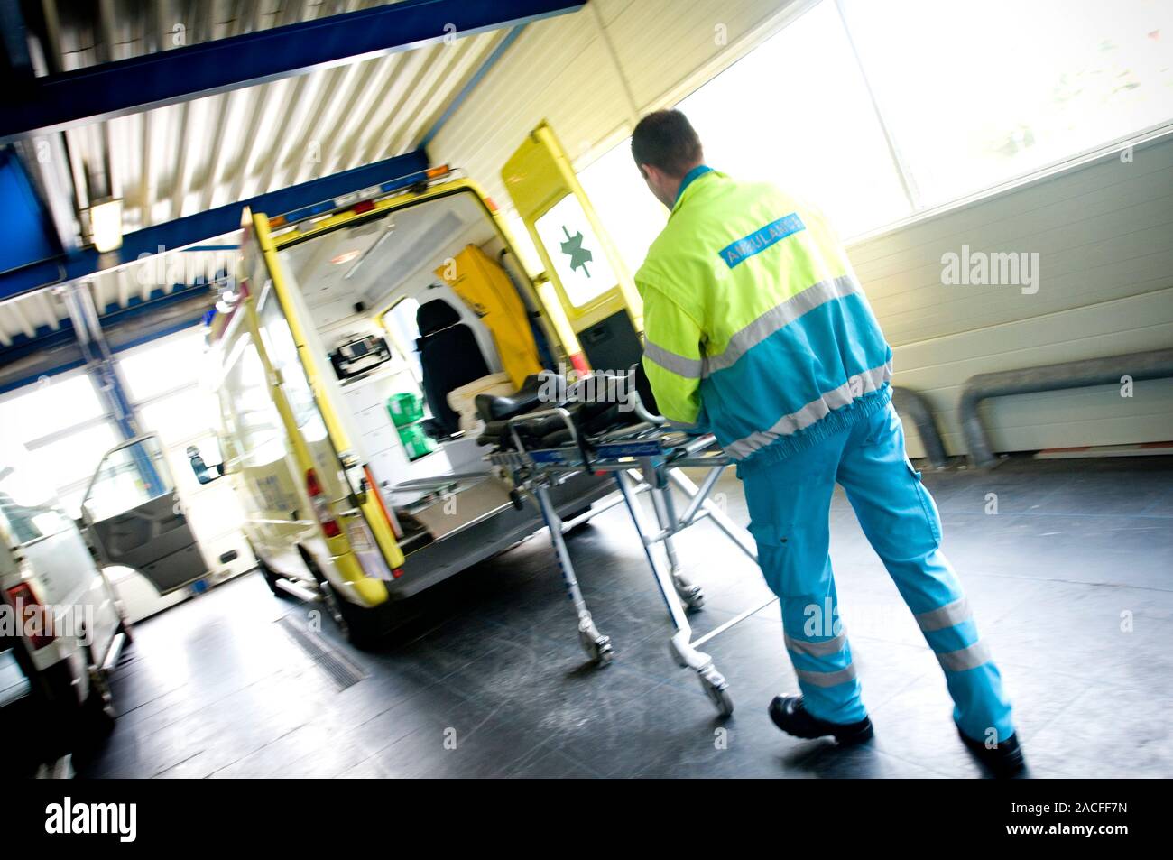 Loading Ambulance Ambulance crew. Paramedic loading a stretcher trolley into the back of ...