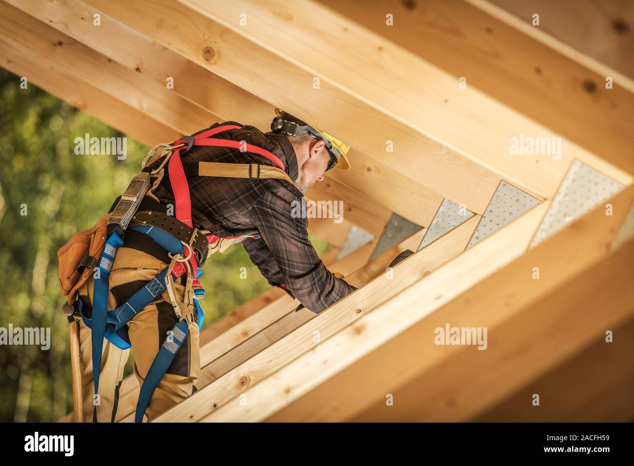 Wooden Roof Frame Construction Work. Caucasian Worker Finishing Wooden Skeleton Frame.Construction Industry. Stock Photo