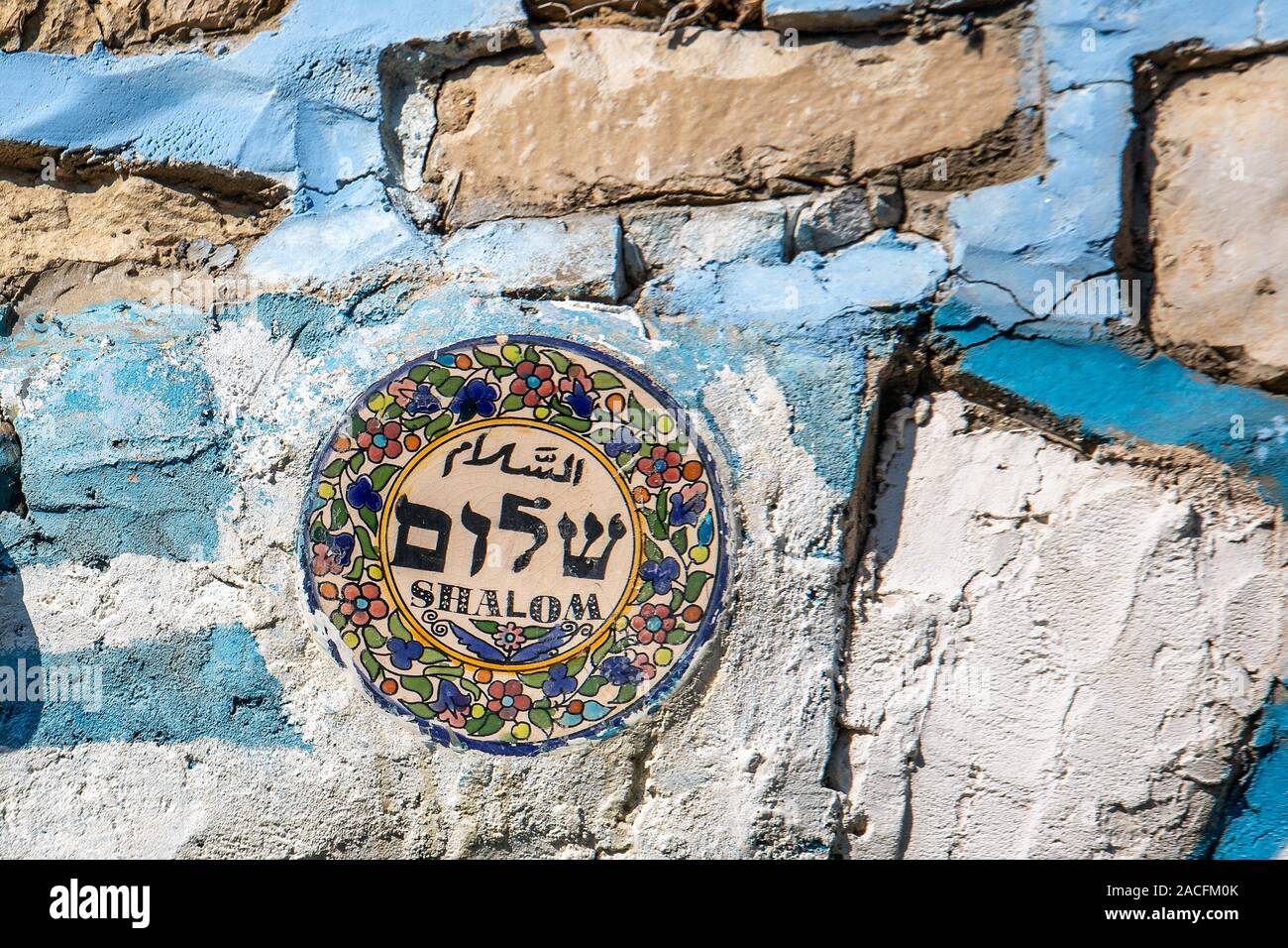 Plate with word peace in three languages in blue streets of Holy city Safed, Israel. Stock Photo