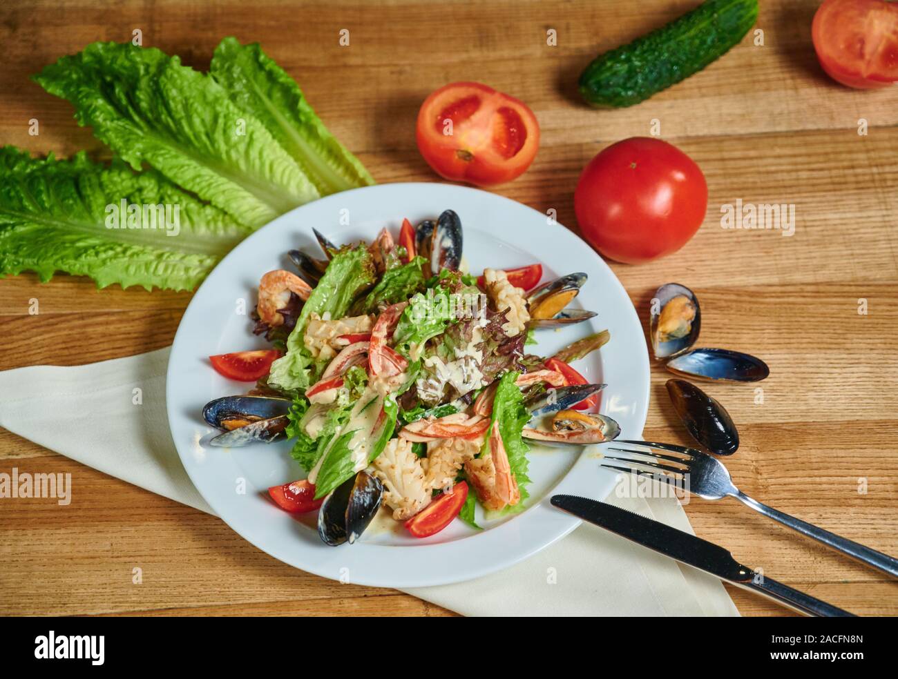 Healthy salad with shrimp, mussels, tomatoes and lettuce leaf, close-up Stock Photo
