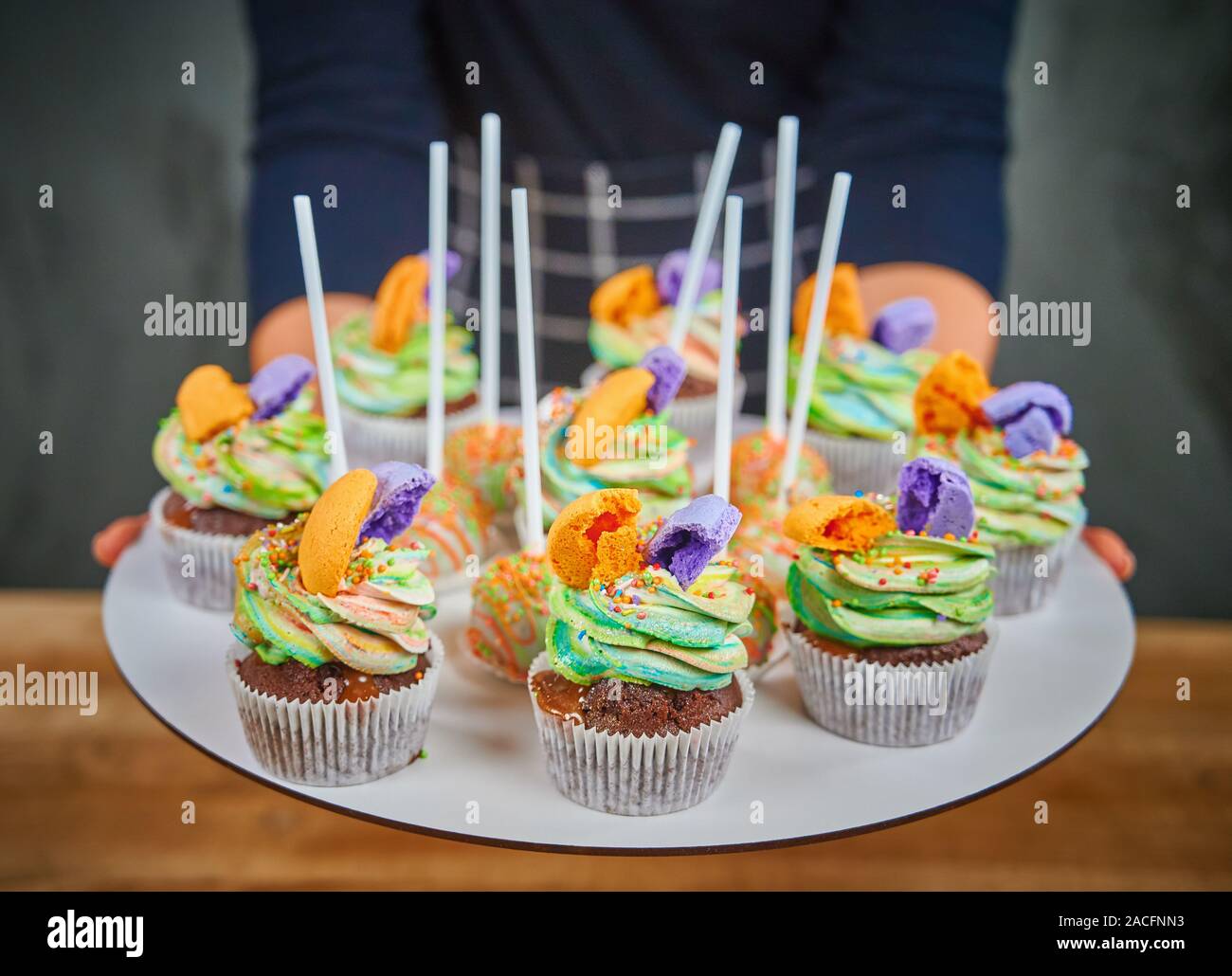 Delicious cupcakes dessert table served for birthday party. Cupcake  decorated colored macarons Stock Photo - Alamy