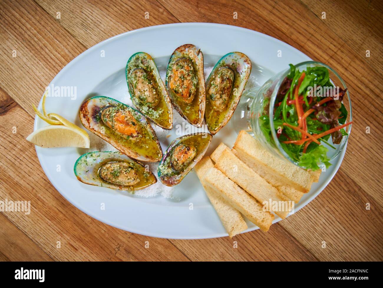 Mussels with garlic sauce serving on white plate in restaurant Stock Photo Alamy