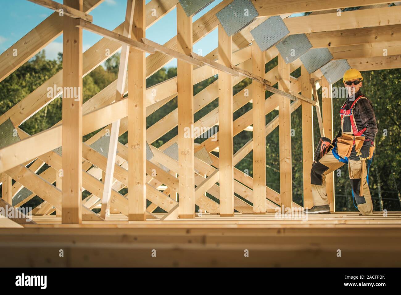 Wood Skeleton Frame Construction Contractor Worker in His 30s. Residential Development. Industrial Theme. Stock Photo