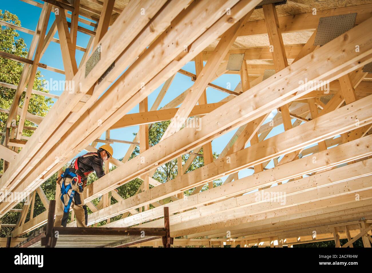Construction Contractor Worker and the Wooden House Frame. Building Development. Stock Photo