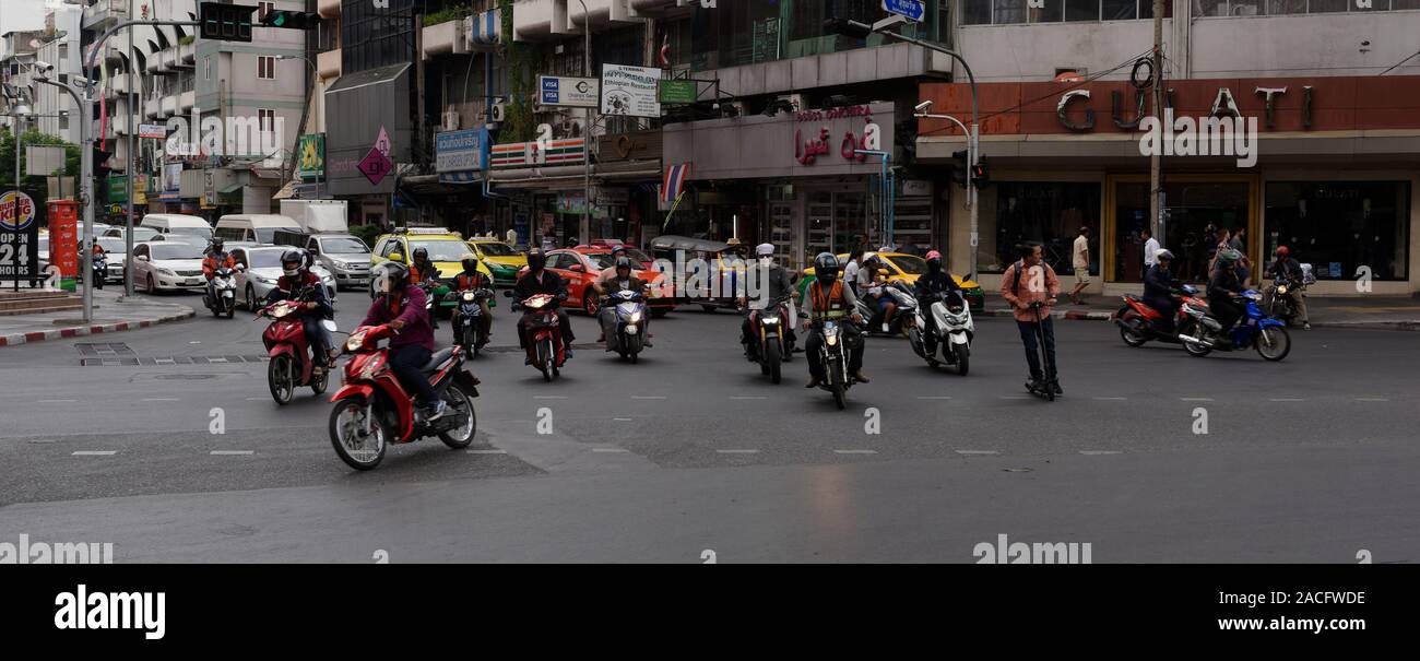 An electric scooter rider defies road safety logic on a busy junction