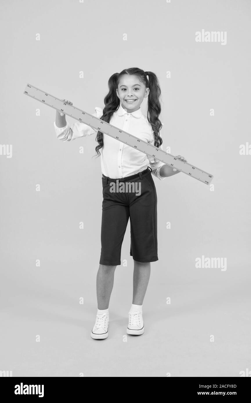 Learning geometry at school. Small school child holding measuring