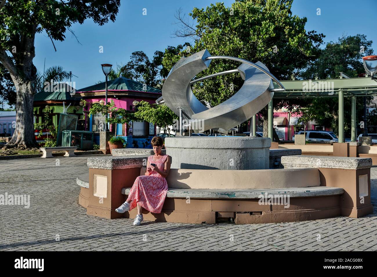 Woman sitting next to modern sculpture, Cabo Rojo Plaza, Cabo Rojo, Puerto Rico Stock Photo