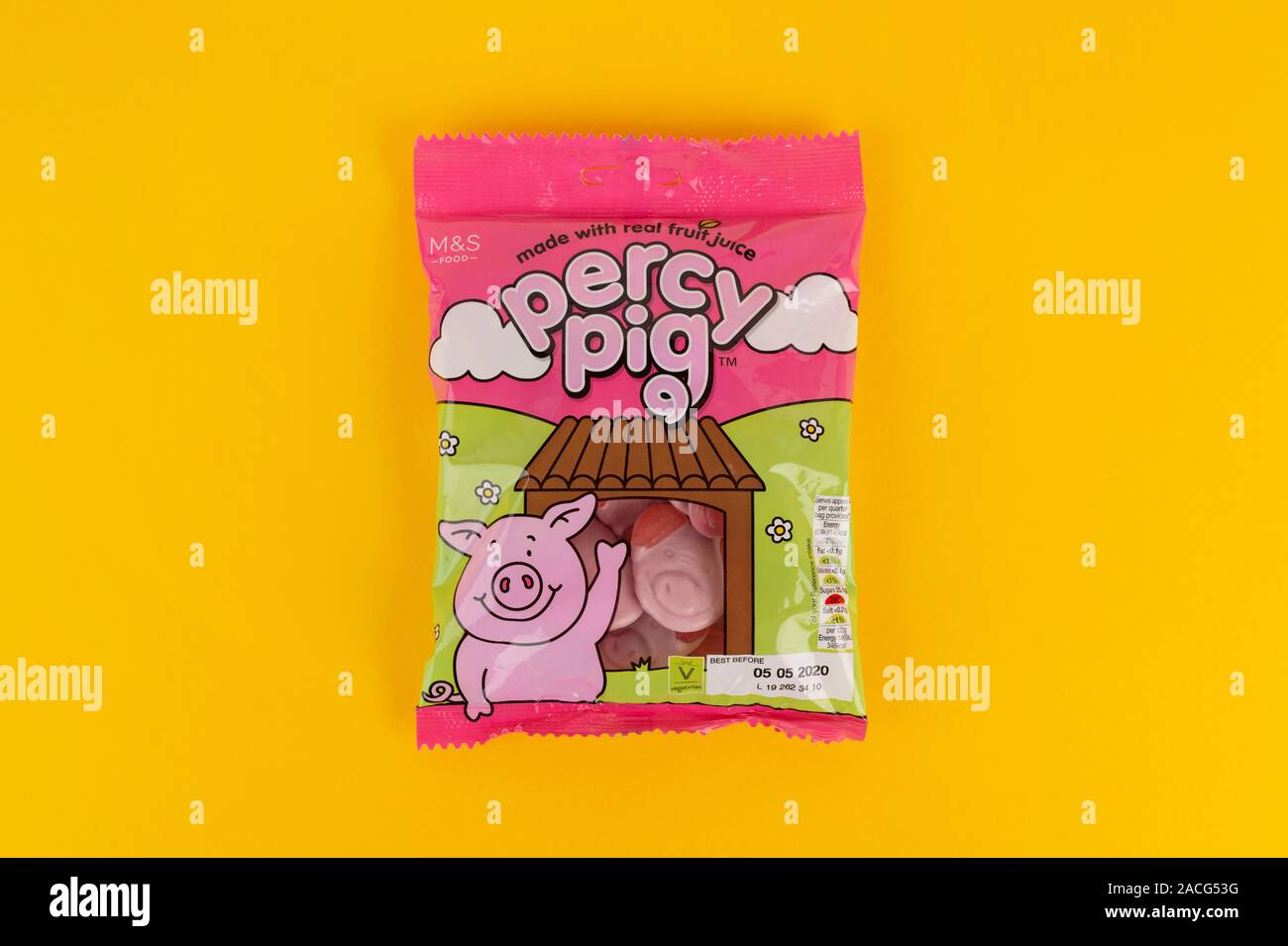 A packet of M&S Percy Pig sweets shot on a yellow background. Stock Photo