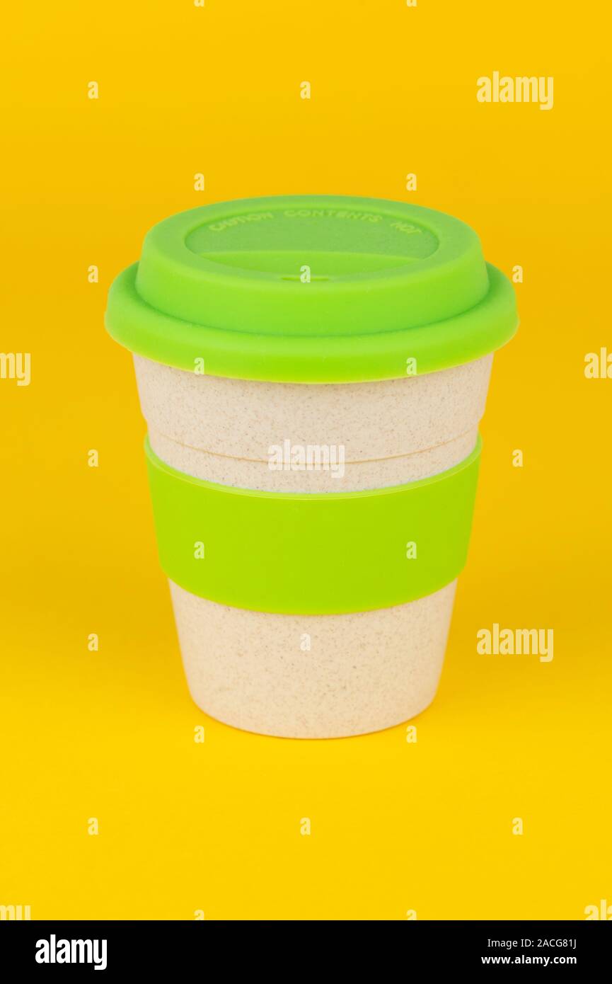 A reusable coffee cup shot on a yellow background. Stock Photo