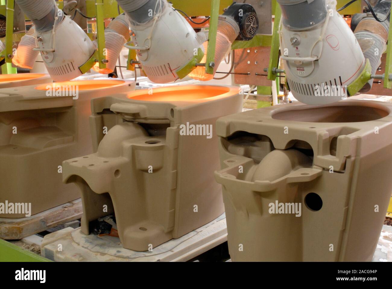 Toilet factory. TOTO toilets on a production line, being heated by lamps during the process of