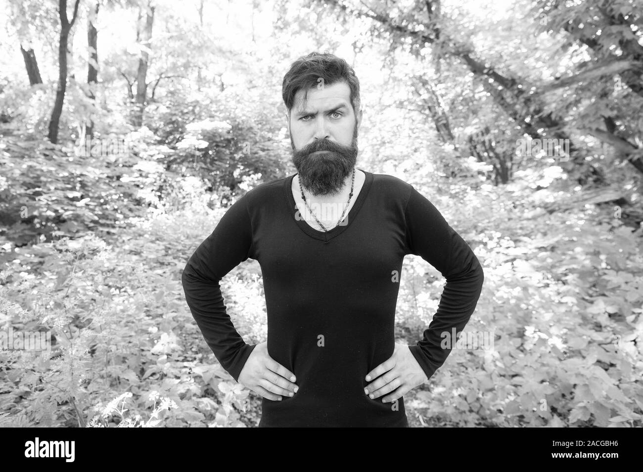 Man bearded hipster bright foliage background. Guy relax in summer forest. Handsome man with beard and mustache summer vacation. Brutality of jungles concept. Summer heat season concept. Wild nature. Stock Photo