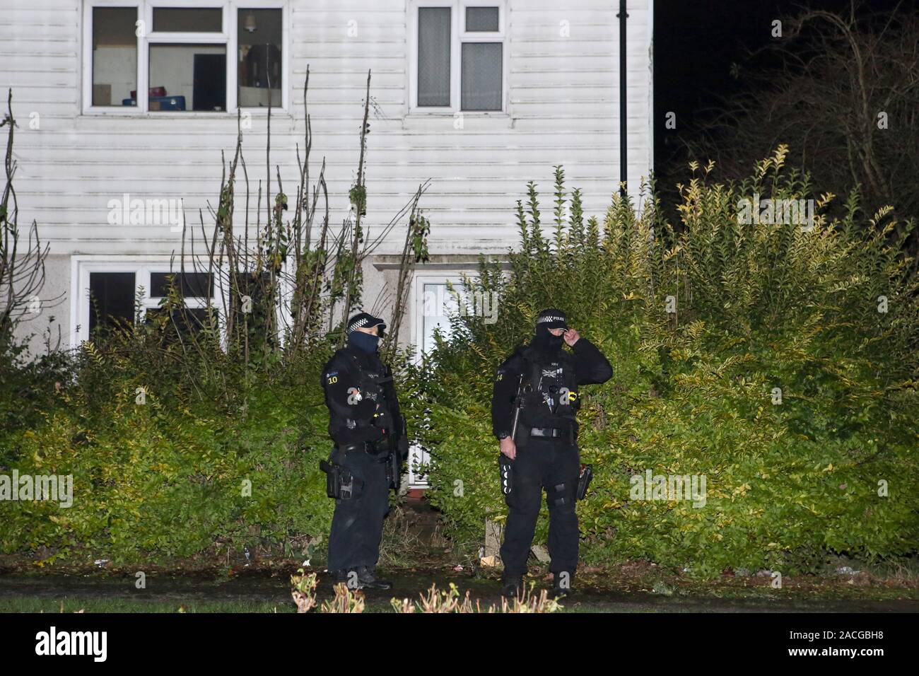 Armed police stand outside a house in Loughton, Essex, thought to be connected to Terry Glover who is currently wanted for questioning after a serious crash near a secondary school on Monday left a 12 year old boy dead and others seriously injured. Stock Photo
