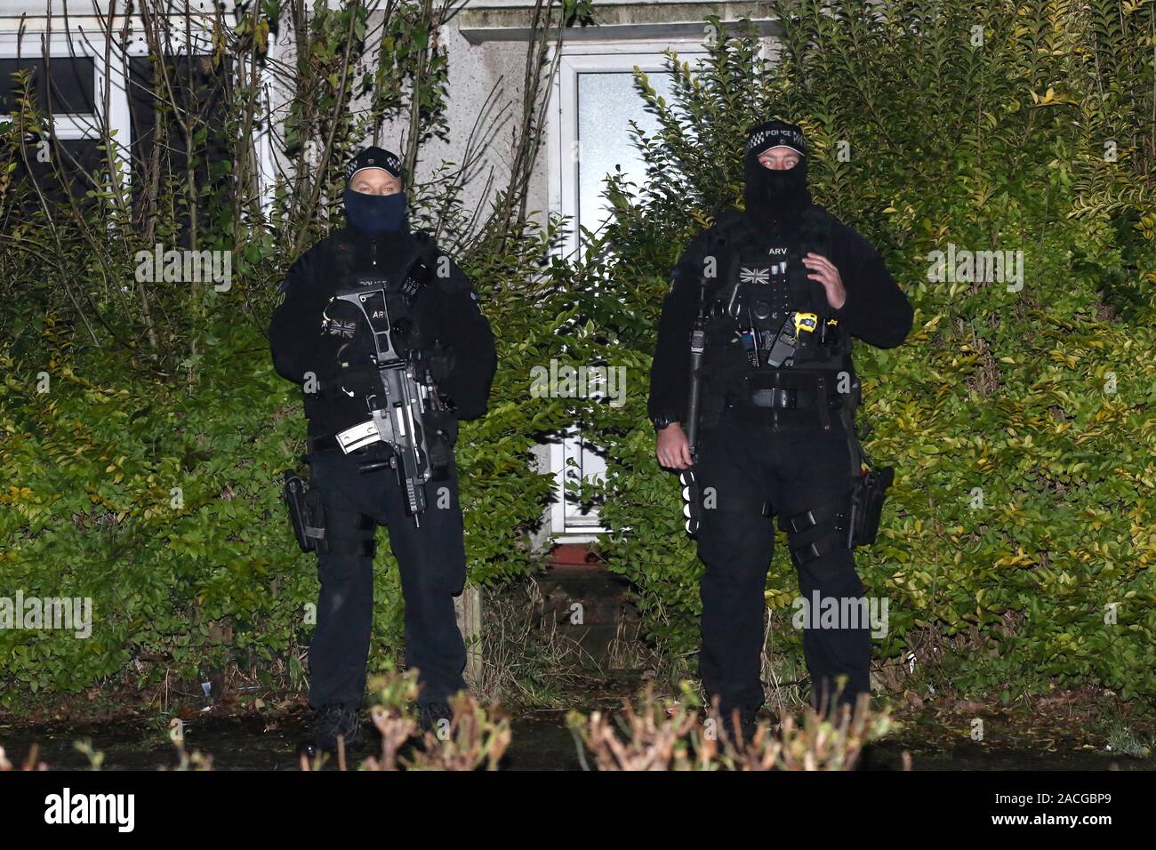 Armed police stand outside a house in Loughton, Essex, thought to be connected to Terry Glover who is currently wanted for questioning after a serious crash near a secondary school on Monday left a 12 year old boy dead and others seriously injured. Stock Photo