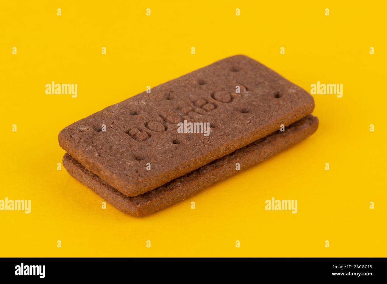 A chocolate Bourbon biscuit shot on a yellow background. Stock Photo