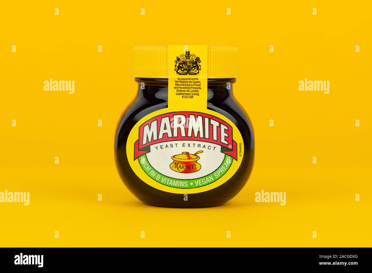 A jar of Marmite shot on a yellow background. Stock Photo