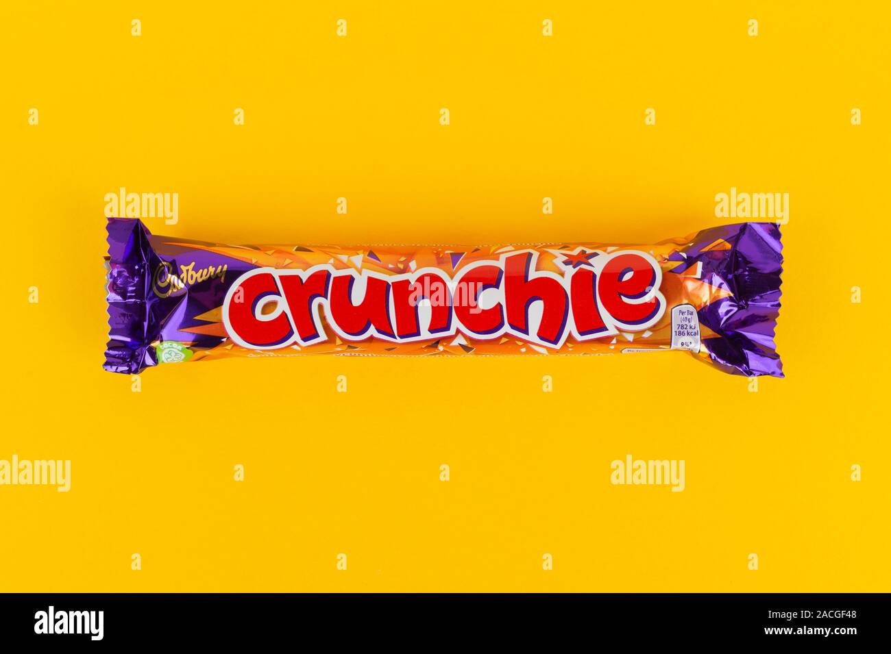 A Crunchie chocolate bar shot on a yellow background. Stock Photo