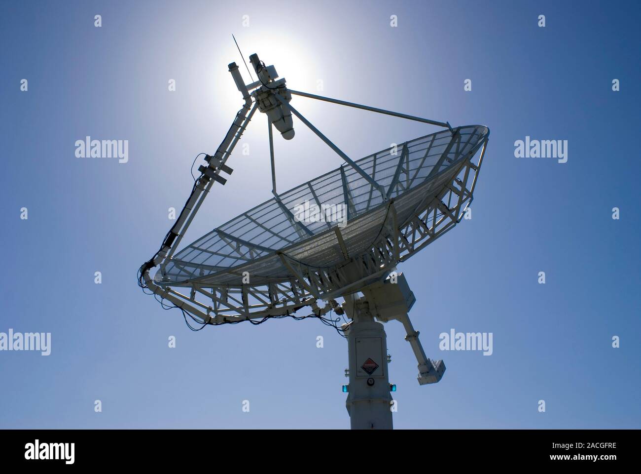 Satellite communications and telemetry antenna, with the Sun behind the