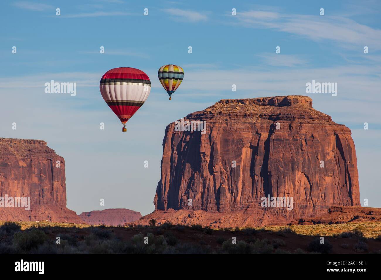 Two hot air balloons fly over Merrick Butte in the Monument Valley Balloon Festival in the Monument Valley Navajo Tribal Park in Arizona.  Sentinal Me Stock Photo