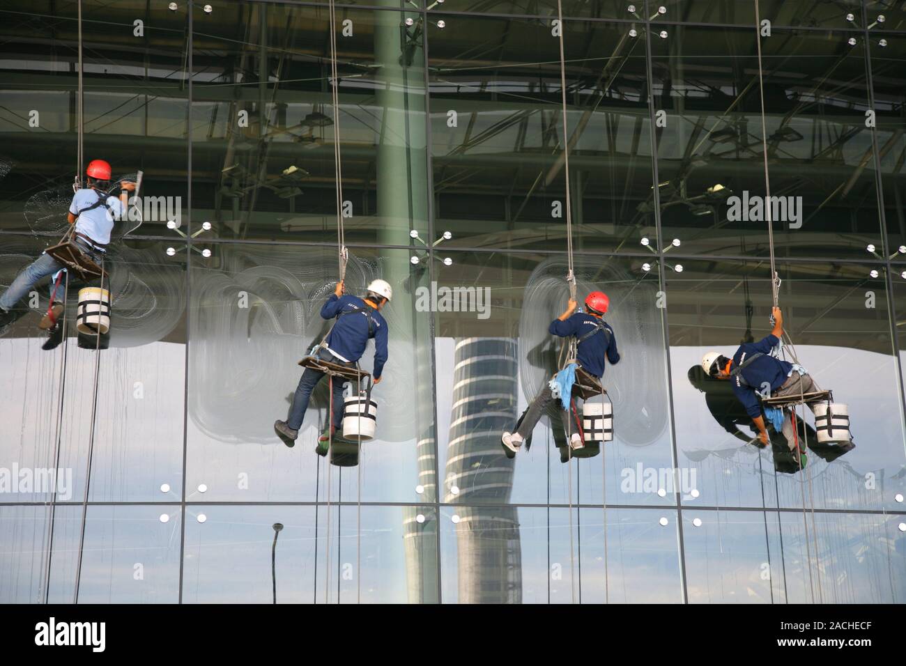 Window Cleaner In Building Industrial window cleaning. Window cleaners seated on wooden slats ...