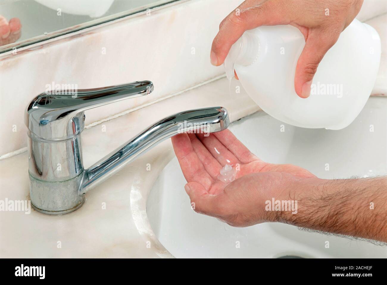 Hand washing. Person washing their hands with liquid soap at a sink ...