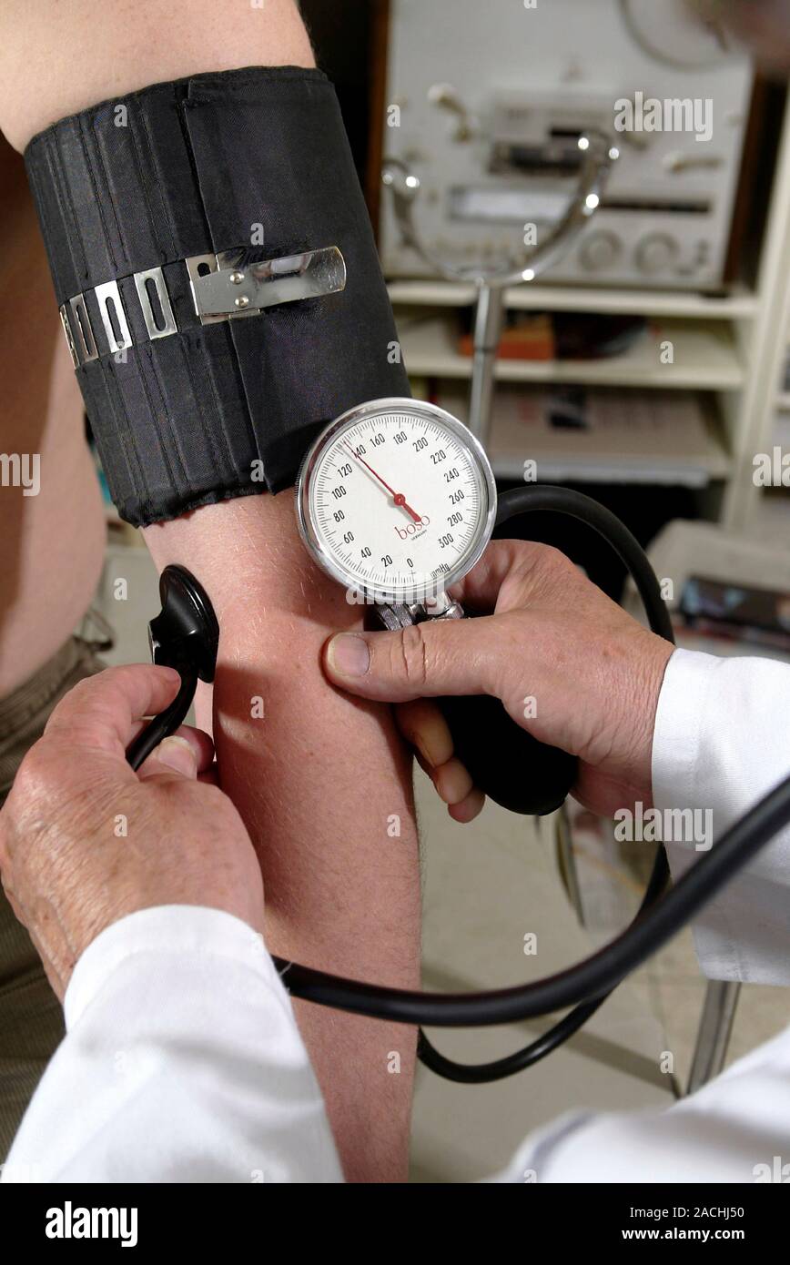 Blood pressure measurement. Sphygmomanometer being used to measure a ...
