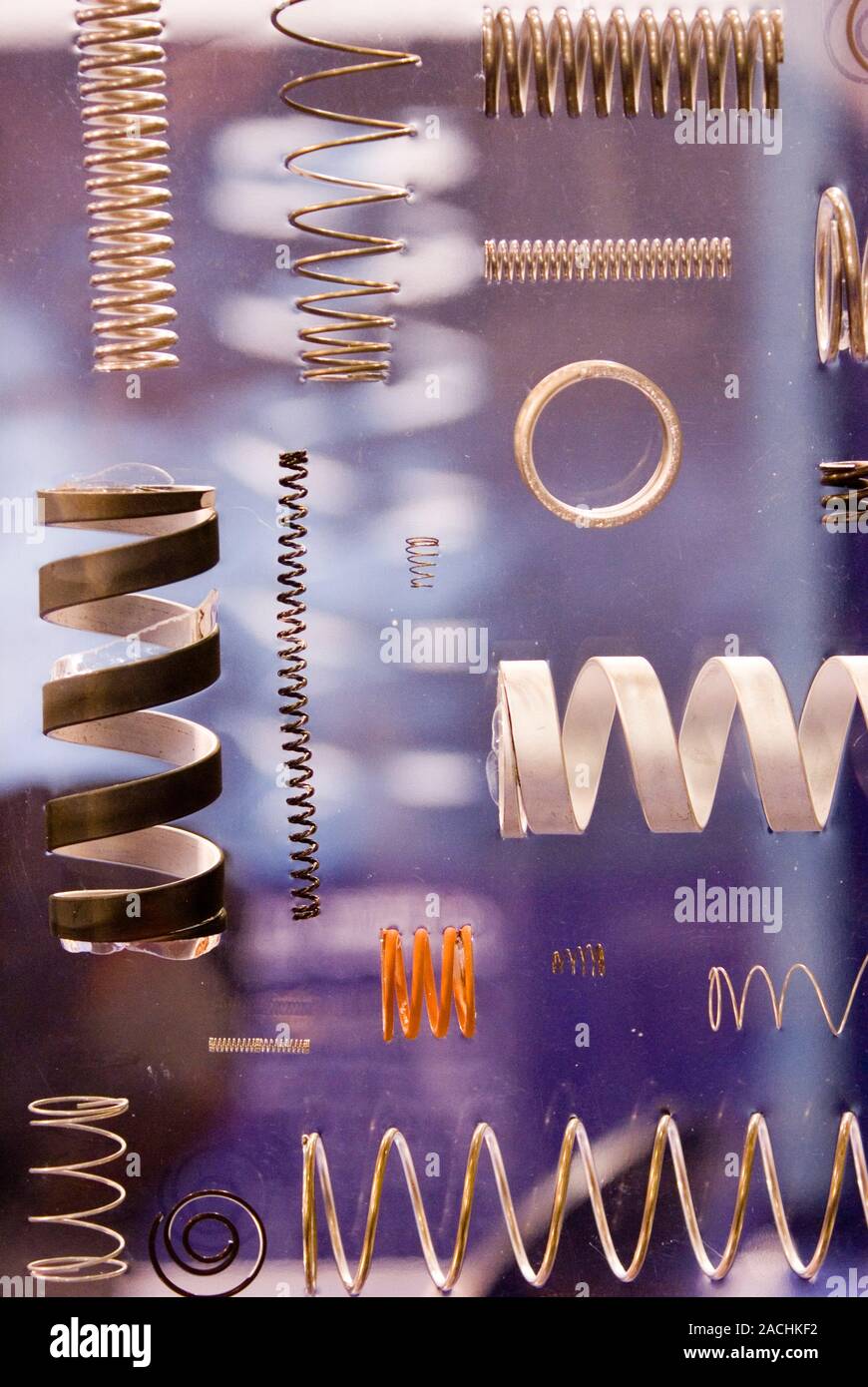 Springs of various types and sizes mounted in Perspex for display. An ...
