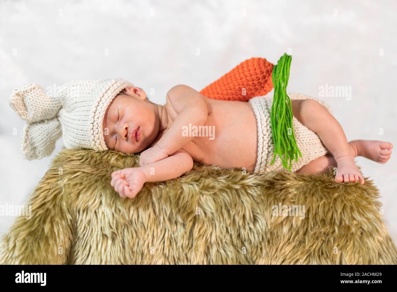 newborn baby in bunny costume sleeping on a fur bed Stock Photo Alamy