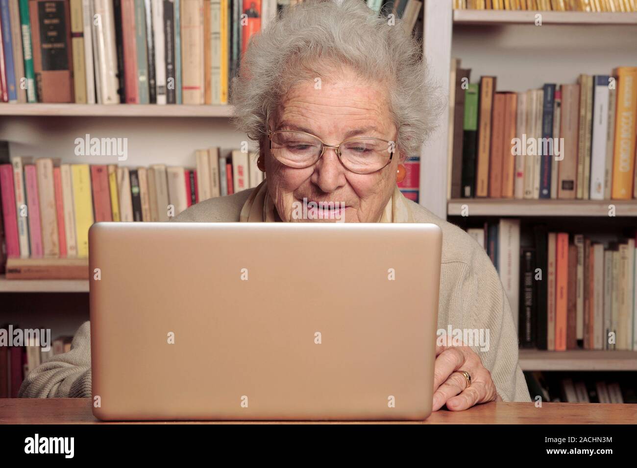 Peering Lady Computer MODEL RELEASED. Elderly lady using a laptop computer Stock Photo - Alamy