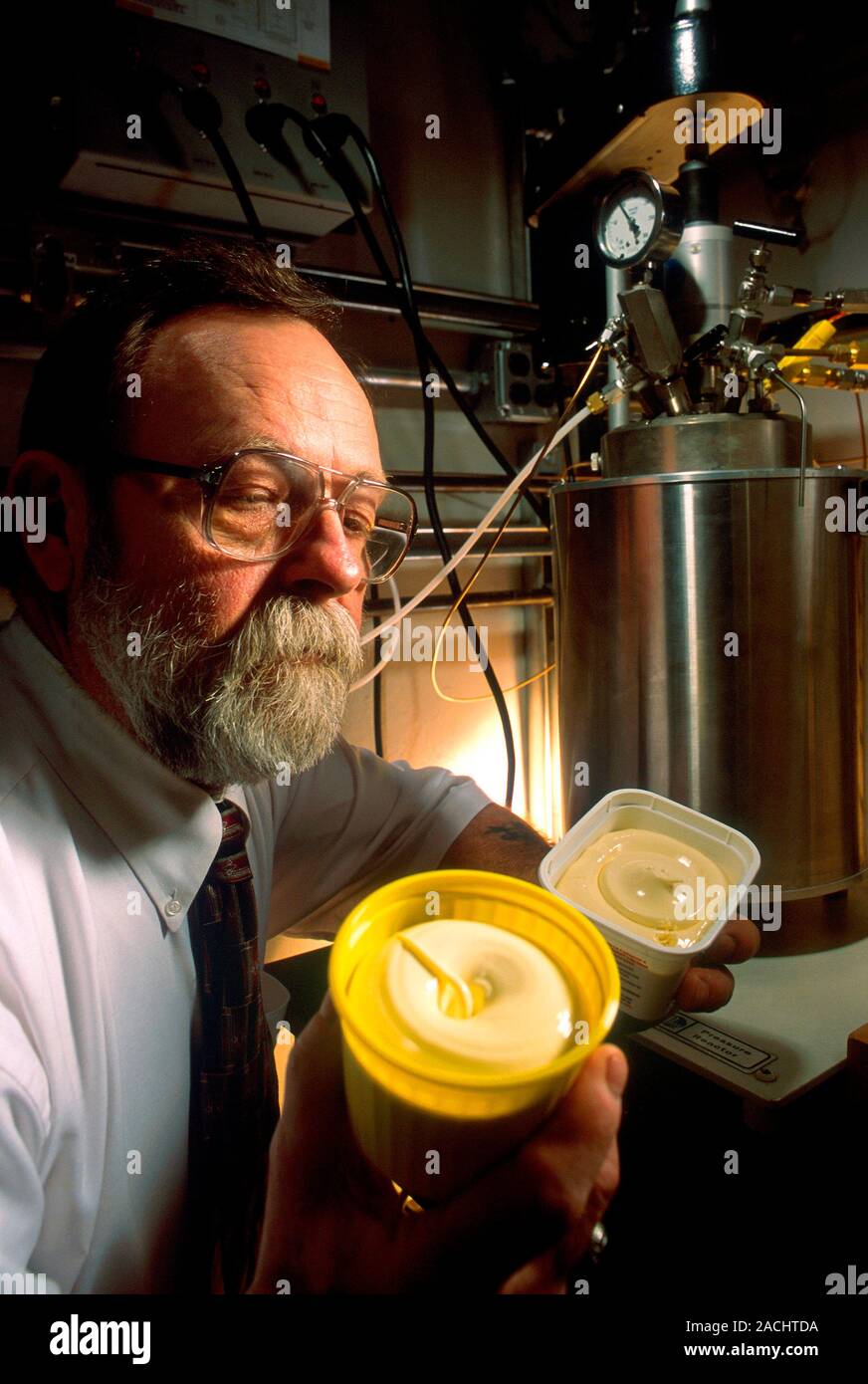 Trans fat food research. Chemist holding tubs of margarine produced ...