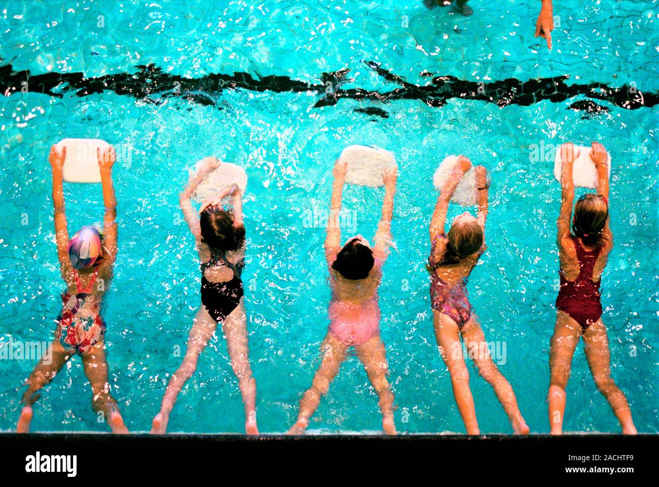 Swimming lesson. Children using floatation aids during a swimming
