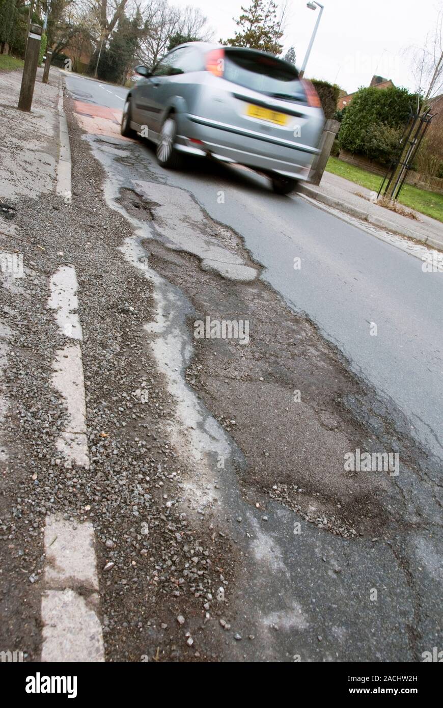 Winter potholes and passing car. These potholes were caused by severe ...