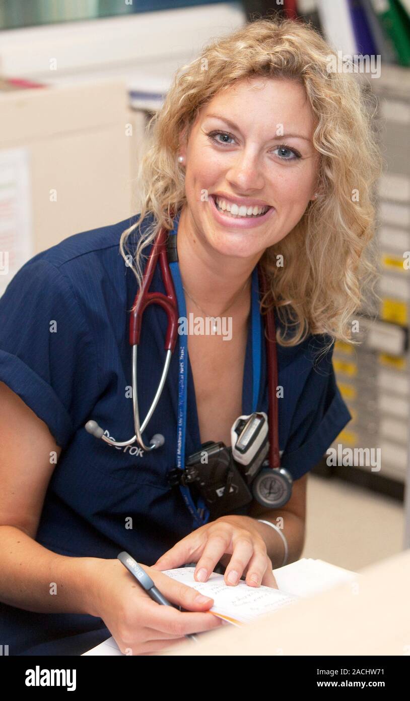 Hospital staff. Doctor looking through patient notes on a ward